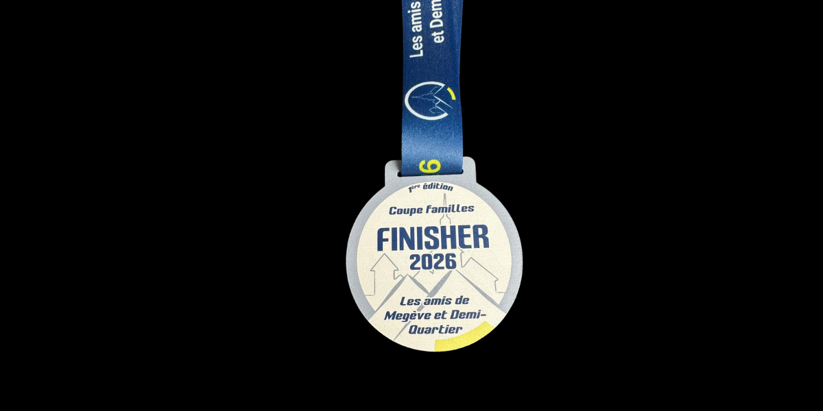 Médaille finisher 2026 en métal argenté avec impression bleue et jaune, créée pour la Coupe Familles de Megève Demi-Quartier, avec ruban personnalisé bleu.